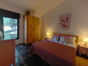 a bedroom with a bed with two lamps and a window at Las Huertas del Abrilongo in La Codosera
