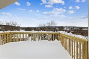 a wooden deck covered in snow with snow on it at Village with a View in Stowe