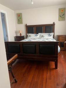 a large bed in a room with a wooden floor at Paul's country cottage in Donegal