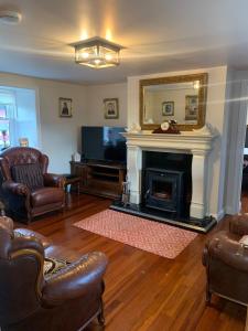 a living room with a fireplace and a television at Paul's country cottage in Donegal