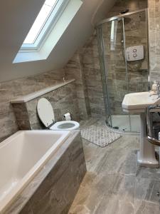 a bathroom with a tub and a toilet and a sink at Paul's country cottage in Donegal