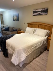 a bedroom with a large bed and a couch at Oceanside Getaway in Nanoose Bay +39 photos