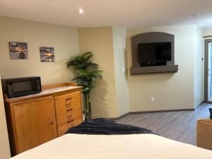 Un dormitorio con una cama y un televisor en la pared. en Oceanside Getaway, en Nanoose Bay