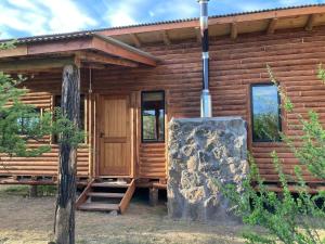 Blockhaus mit einer Treppe, die zur Tür führt in der Unterkunft Cabaña frente al lago in La Estancia