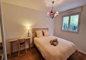 une chambre avec un lit avec un bureau et une fenêtre dans l'établissement Appartement avec jardin - Claye-Souilly, à Claye-Souilly