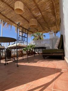 un patio avec des tables et des chaises sous un toit dans l'établissement Riad Casa Sophia, à Marrakech