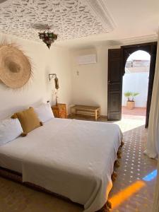 une chambre avec un grand lit blanc dans une pièce dans l'établissement Riad Casa Sophia, à Marrakech
