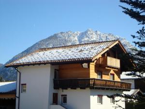 a wooden house with a balcony and a mountain at Apartments Schöll in Reutte