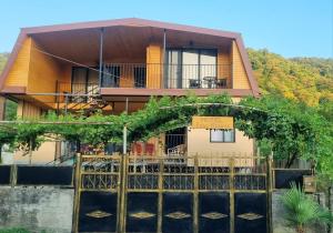 a house with a fence in front of it at Four Rooms in Lagodekhi