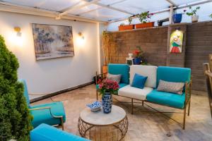 a patio with blue chairs and a couch at Adamas House Hotel Boutique in Quito