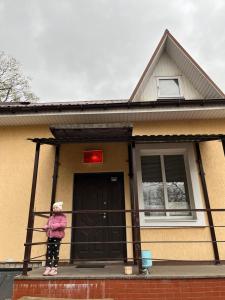 a person standing in front of a house at Seven Hotel VIP in Korostenʼ