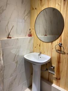 a bathroom with a white sink and a mirror at Casa Prusia, tipica de pioneros europeos in Aristóbulo del Valle +11 photos