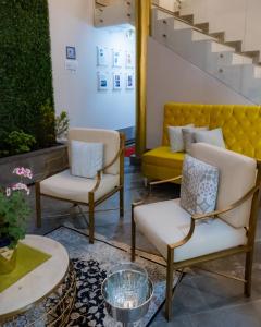 two chairs and a yellow couch in a room at Adamas House Hotel Boutique in Quito