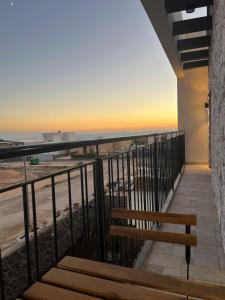 a bench on a balcony with a view of the ocean at צימר בלב הגולן קצרין in Qasrîne +2 photos