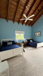 een slaapkamer met twee bedden en een plafondventilator bij Portillo Villa Loft 7BR in El Limón