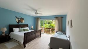 een slaapkamer met blauwe muren en een bed en een balkon bij Portillo Villa Loft 7BR in El Limón