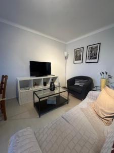 a living room with a bed and a tv at Sunset Paradise in Caminha