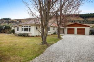 a white house with a brown garage at Clyde on Sunderland in Clyde