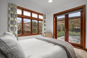 a bedroom with a bed and a large window at Clyde on Sunderland in Clyde