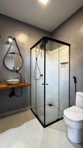 a bathroom with a glass shower and a toilet at Chalés da Bica - Modernidade e Aconchego a 100m da Praia in Paracuru