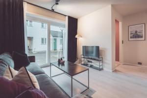 a living room with a couch and a tv at Modern Flat In Tromsø Centre in Tromsø