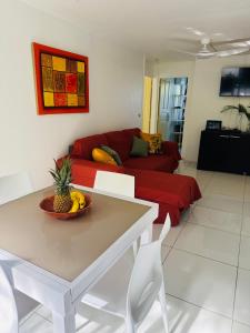 Résidence Oncle Sam في لو جوسيير: غرفة معيشة مع طاولة وأريكة حمراء