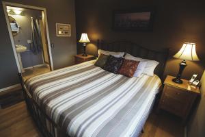 a bedroom with a large bed with two lamps at Olympic View Cottage in Gregory Heights