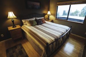 a bedroom with a bed with two lamps and a window at Olympic View Cottage in Gregory Heights