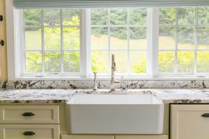 a white sink in a kitchen with two windows at VERt MONsTre in Stowe +32 photos