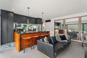 a living room with a couch and a bar at Charming Lakeview Home ! in Queenstown +8 photos