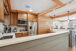 une cuisine avec des placards en bois et des comptoirs blancs dans l'établissement Trapp Alpine Chalet, à Stowe Fork