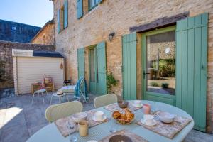 Salignac EyviguesMaison T3 tout confort et spa Le Clos des Pierres的天井配有餐桌和食物