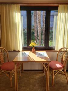 a wooden table with two chairs and a window at Casa Adelizia in Ascona