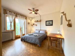 a bedroom with a bed with a ceiling fan and a table at Parcheggio Privato - 5 minuti dal Lago di Varese in Varese