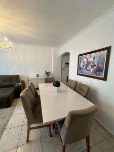 a living room with a white table and chairs at Vista ao mar no Gonzaga in Santos