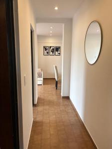 pasillo con espejo y habitación con silla en Rincon del Oceano, en Santa Teresita