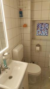 a white bathroom with a toilet and a sink at The Cozy Nest Retreat in Bucharest +6 photos