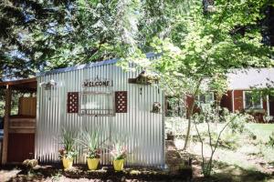 a metal shed with potted plants in a yard at Moon Mountain Lodging in Packwood