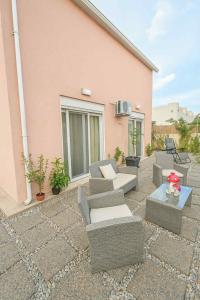 a patio with couches and chairs and a table at The 50 50 Deluxe Apartments in Sidari