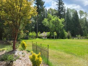 a fence in a field with a tree at Moon Mountain Lodging in Packwood