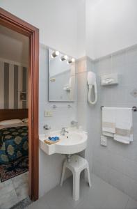 baño con lavabo, espejo y cama en Hotel Redebora, en Torregrotta