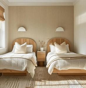 a bedroom with two beds with white pillows at The Pointe Taveuni in Matei