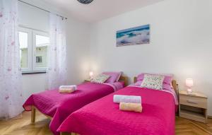 two beds in a room with pink sheets at Cozy Home In Tinjan in Tinjan