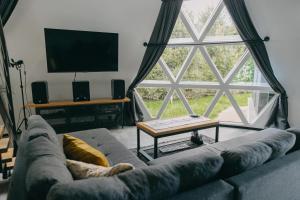 a living room with a couch and a large window at Dome Noire in Puškarič Selo
