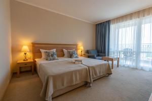 阳光海滩DIT Majestic Beach Resort的一间带大床和大窗户的卧室