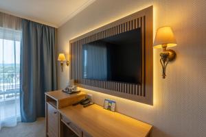 阳光海滩DIT Majestic Beach Resort的酒店客房的墙上设有大屏幕电视