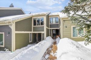 a house with snow in front of it at Topnotch Retreat in Stowe