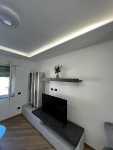 a living room with a flat screen tv on a white wall at Cantalupo 3 in Cantalupo