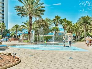 Un gruppo di persone che giocano in una fontana di 5 Star Resort 6th fl 2BR 2 BATH King Suite Shuttle Pools Family a Destin