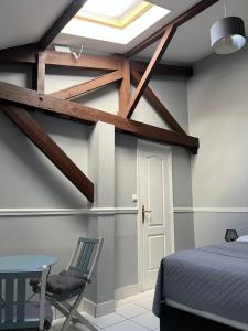 a bedroom with a bed and a table and a window at Nid Parisien in Cachan